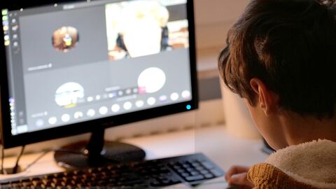 Schüler in einer Videokonferenz Ein Junge sitzt vor einem Bildschirm und nimmt an einer Videokonferenz teil.