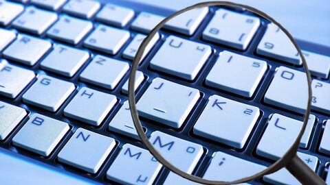 Lupe über einer Tastatur Lupe über einer Tastatur